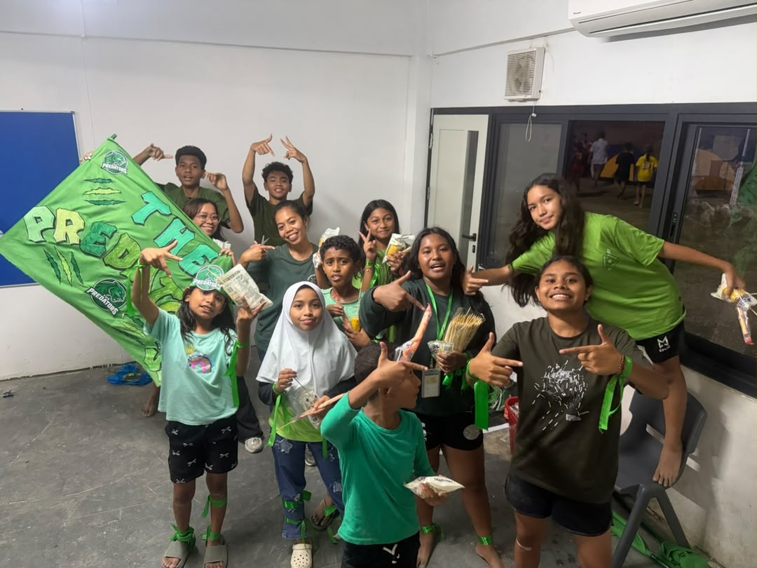 The green team celebrating with their banner at camp