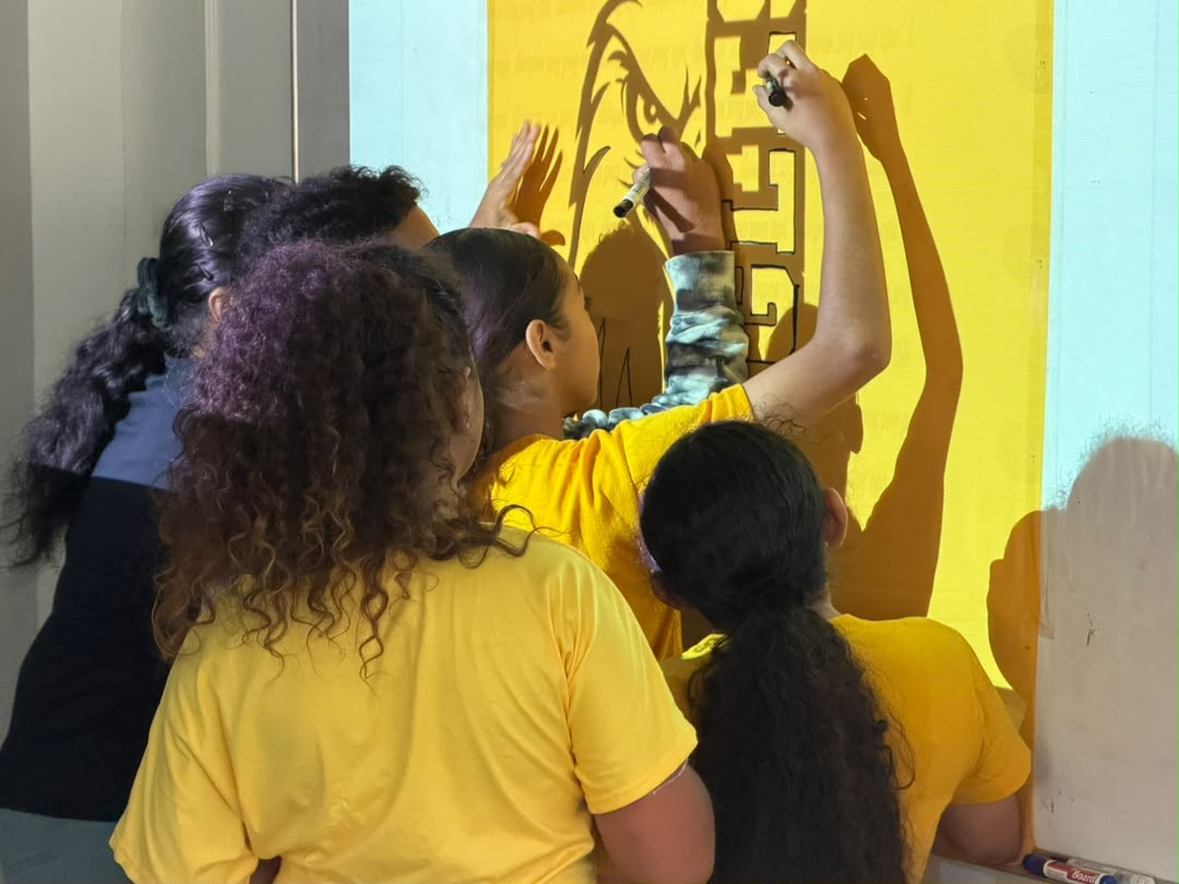 Students painting a large yellow team banner